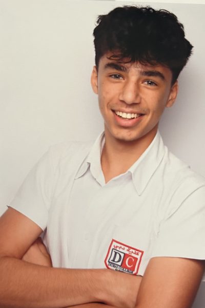 Young man smiling in white shirt.