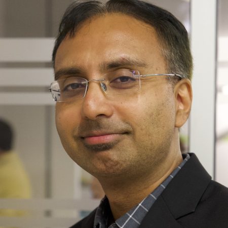 Man wearing glasses and a black blazer.